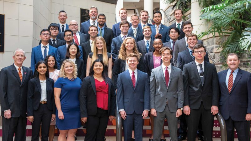 MSBA-BA Cohort 3 students stand in rows on the steps inside Pamplin Hall's atrium.