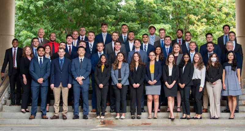 MSBA-BA Cohort 6 students stand in rows on the steps outside Pamplin Hall's atrium.
