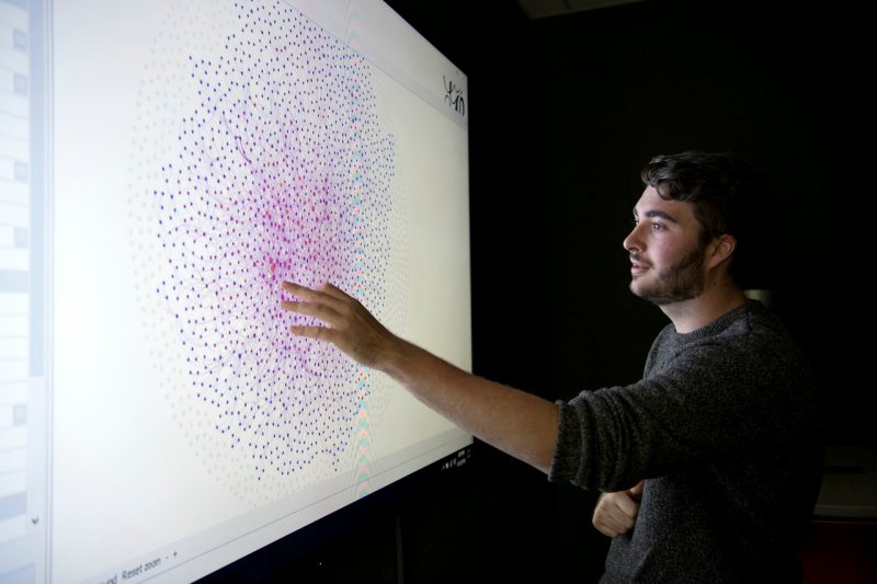 A student manipulates data on a large touchscreen